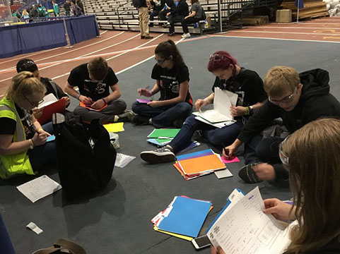 The team working together, reviewing scouting sheets, to form a list of potential alliance partners.