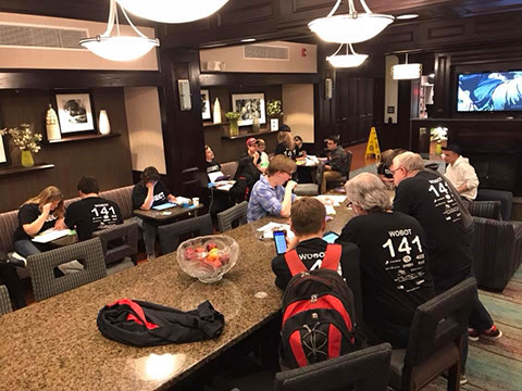 The team working together, reviewing scouting sheets, to form a list of potential alliance partners.