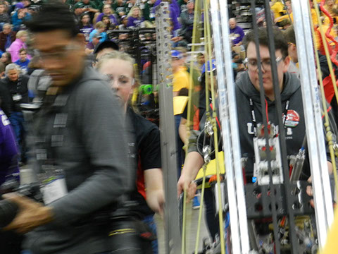The team technician pushing the robot from the field to the pits.