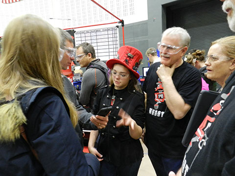 The team talking to visitors with an Engineering Scavenger Hunt for a homework assignment.